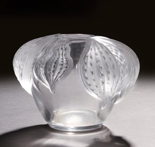 Marie-Claude LALIQUE (1935-2003)  
San Diego, modèle créé en 1989
Vase ovoïde.
Épreuve en cristal soufflé moulé.
Les parties décoratives latérales, achevées en satiné, évoquent des algues s’enroulant sur un rocher représenté par le corps du vase.
Signé LALIQUE © France, gravé sous la base.
Hauteur  : 16 cm
