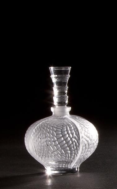 LALIQUE Parfums – Fondé par Marie-Claude LALIQUE (1935-2003)
Flacon Peau de Serpent
Corps en cristal soufflé moulé et en partie satiné.
Bouchon en cristal moulé pressé et en partie satiné.
Signé LALIQUE ® France en lettres cursives sous la base.
Hauteur : 12 cm