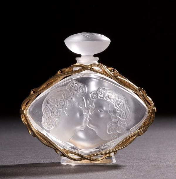 LALIQUE Parfums – Fondé par Marie-Claude LALIQUE (1935-2003)
Le Baiser, Collection 2000
Flacon de parfum.
Corps en cristal soufflé moulé et, en partie, satiné, enchâssé dans une monture en métal doré à l’or fin.
Bouchon en cristal moulé pressé.
Édition limitée et numérotée B 574.
Signé LALIQUE © France en lettres cursives sous la base.
Hauteur  : 11 cm