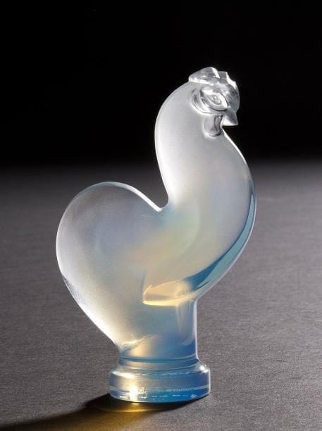 Maison LALIQUE
Coq stylisé, 28 février 2002
Motif décoratif.
Épreuve en cristal opalescent moulé pressé.
Signé LALIQUE ® France en lettres cursives, gravé sous le tranche de la terrasse et daté 28-02-2002 sous la base.
Diamètre  : 12,8 cm