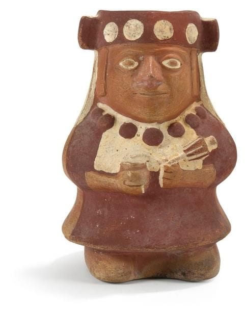 Vase représentant une femme en costume d?apparat. Terre cuite brune à engobe crème et rouge. Culture Mochica, Pérou 400 - 100 av. J.-C. H: 20 cm - l: 13 cm - l: 13 cm État: Cassé, petit manque et restauration. Provenance: Collection de M. G., France