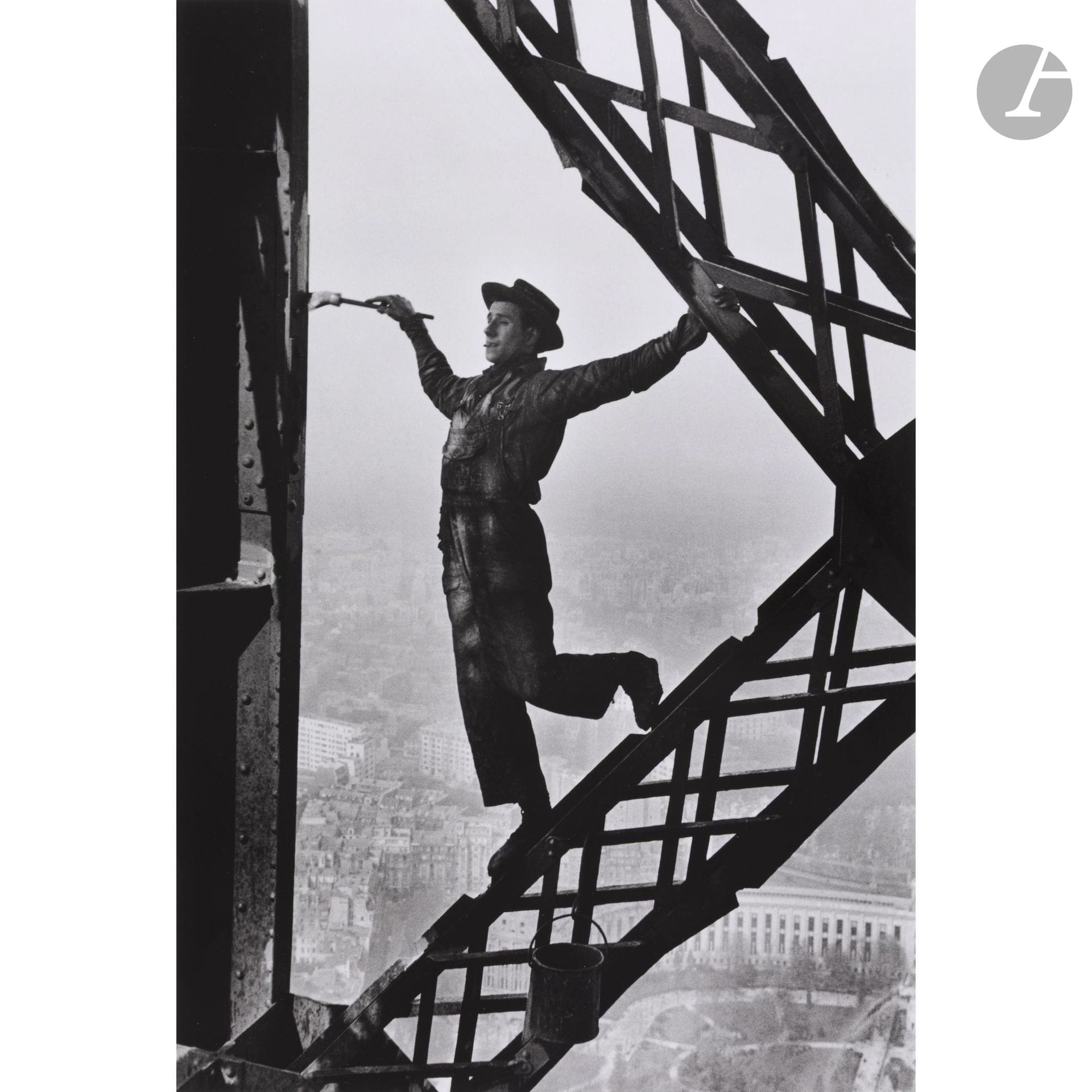 Marc Riboud (1923-2016)
Le peintre de la tour Eiffel. Paris, 1953.
Épreuve argentique (c. 1990), signée et dédicacée au crayon dans la marge en bas à droite. Tampon « Marc Riboud 48, rue Monsieur le Prince » et signature au crayon au verso. 
Image : 36,2 x 24,5 cm 
Feuille : 40,5 x 30,5 cm

Bibliographie :
Marc Riboud, Photo Poche N° 37, CNP, Paris, 1982, ill. 62.

« Le peintre, surnommé Zazou, est à son aise, j’avais le vertige et je fermais les yeux chaque fois qu’il se penchait pour tremper son pinceau… » Marc Riboud