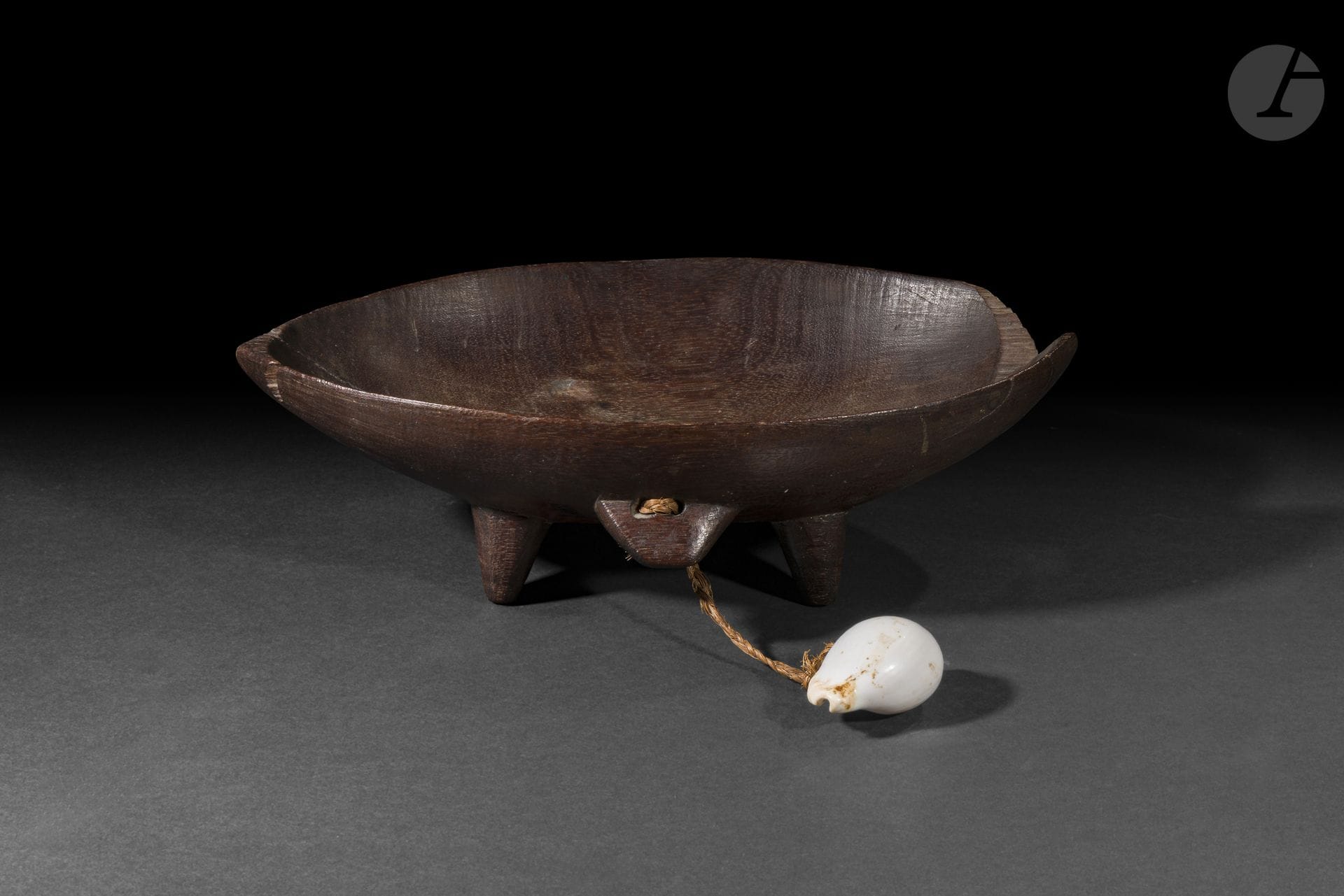 Bol à kava (kumete), archipel des îles Tonga
Hauteur : 21,5 cm
Bois et coquillage.
Destiné à la préparation et au service du kava, le kumete occupait une place essentielle dans les cérémonies coutumières tongiennes. Ce bel exemplaire (bien qu’ébréché) conserve un coquillage suspendu à l’une de ses prises, détail caractéristique de certains bols anciens, qui souligne le soin apporté à la réalisation de ces récipients cérémoniels.

Provenance : 
Galerie américaine.