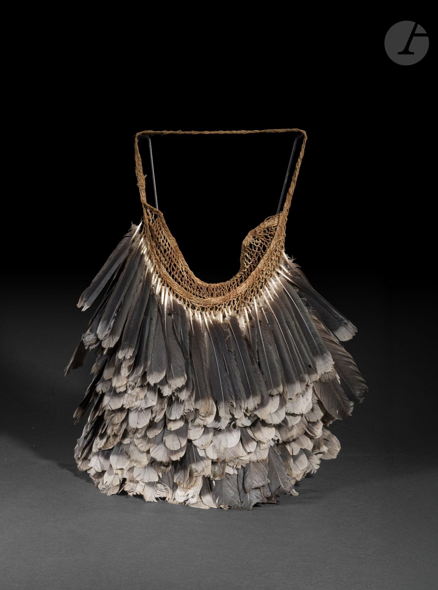 Sac en plumes, Dani, Région des Hautes Terres, Papouasie-Nouvelle-Guinée
Hauteur : 42 cm
Fibres végétales et plumes.
Réalisé en fibres végétales et orné de plumes, ce sac était porté lors des cérémonies et des rassemblements importants. Il témoigne du raffinement des productions des Hautes Terres de Papouasie, où les parures de plumes occupaient une place essentielle dans l’expression du prestige et de l’identité.

Provenance : 
Galerie américaine.