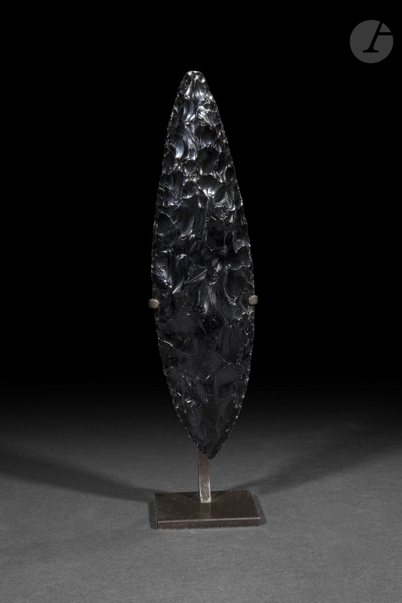 Couteau « feuille de laurier » en obsidienne, Mexique
XIXe siècle
Hauteur : 24 cm
Obsidienne.
Taillé avec une remarquable maîtrise dans une obsidienne de grande qualité, ce couteau en forme de feuille de laurier illustre l’excellence des traditions lapidaires de l’ancien Mexique. La finesse de sa retouche bifaciale et la parfaite symétrie de sa silhouette témoignent d’un exceptionnel savoir-faire technique, faisant de ce type d’objet l’une des réalisations les plus abouties de la taille de l’obsidienne en Mésoamérique.

Provenance : 
Galerie américaine.