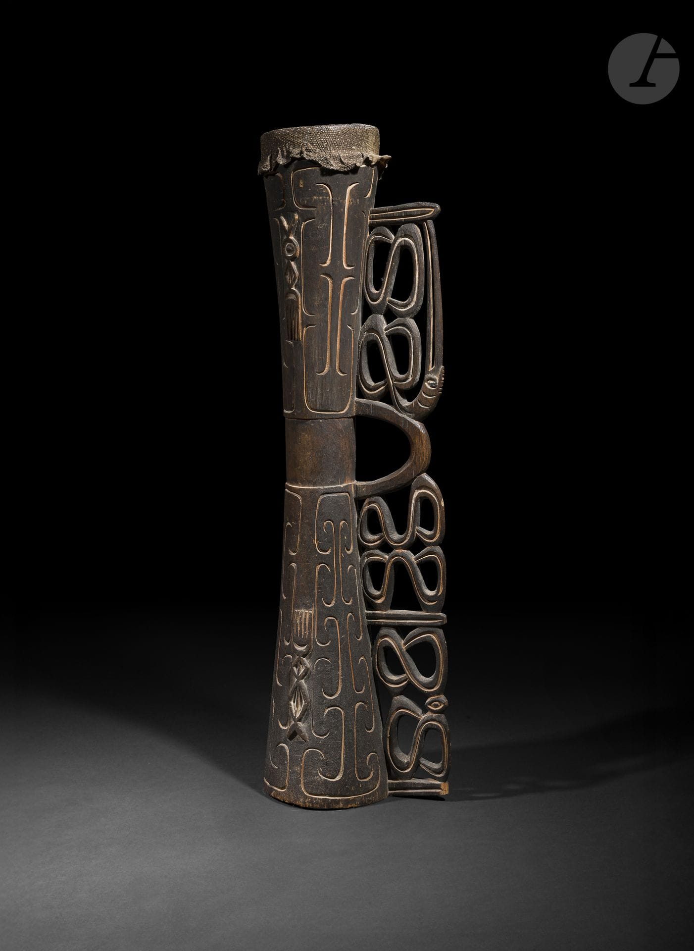 Tambour, région Massim, Papouasie-Nouvelle-Guinée
Longueur : 90 cm
Bois, pigments, peau de serpent.
Caractéristique des productions de la région Massim, ce tambour présente un décor de volutes finement gravées et sculptées, emblématique du vocabulaire ornemental local. Associant fonction musicale et qualité sculpturale, il témoigne de la remarquable maîtrise des artisans, dont les compositions curvilignes comptent parmi les plus raffinées de l’art océanien.