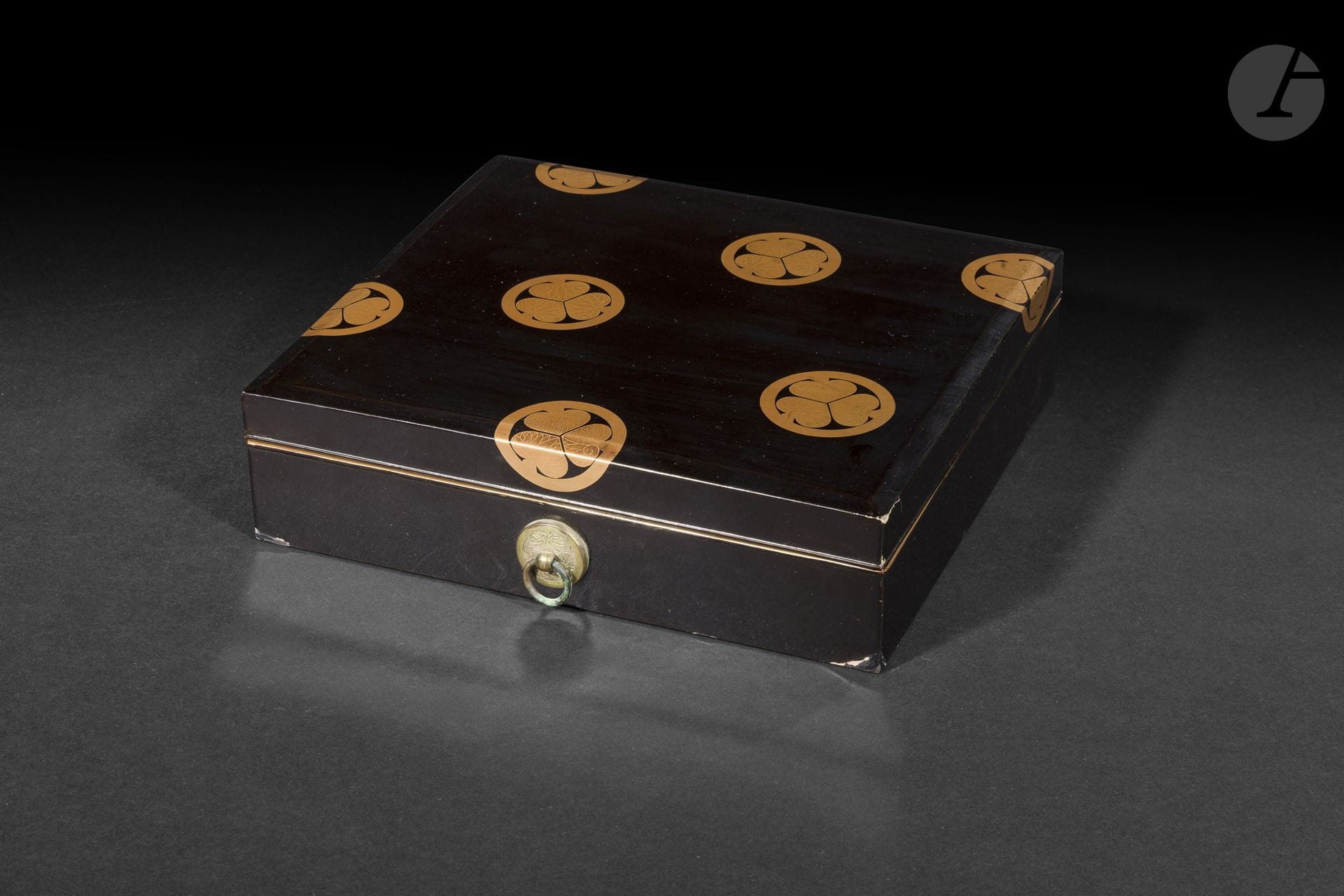 Shikishi bako en bois laqué à fond noir, Japon, époque Meiji (1868-1912)
Boîte de forme carrée à fond laqué ro iro décorée en hiramaki e or d’aoi no mon, armoiries de la famille Tokugawa. Sur chaque côté un kanamono ciselé du même décor monté avec un anneau mobile pour le passage d’un cordon. L’intérieur en laque nashiji.
22,7 x 20,4 cm
Accidents et manques dans certains coins du couvercle et de la base.