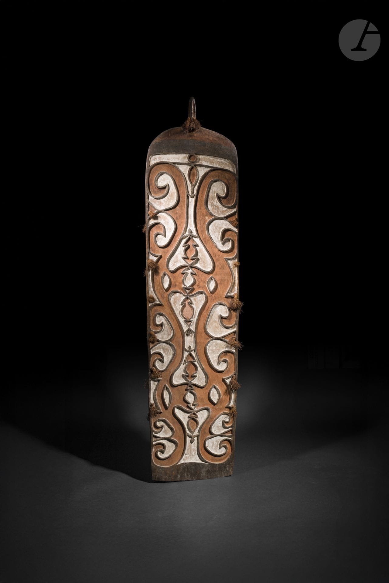 Bouclier Asmat, Papouasie occidentale, Papouasie-Nouvelle-Guinée
Hauteur : 139 cm
Bois et pigments.
Ce remarquable bouclier se distingue par la profondeur de sa sculpture et la richesse de sa polychromie, encore largement préservée. Les figures ancestrales et les motifs qui animent sa surface témoignent de la vigueur des traditions artistiques asmat, où ces boucliers occupaient une place essentielle dans la protection symbolique et l’affirmation de l’identité du groupe. La qualité de son exécution en fait un bel exemple de l’une des plus importantes traditions sculpturales de Nouvelle-Guinée.

Provenance : 
Vente aux enchères, USA.