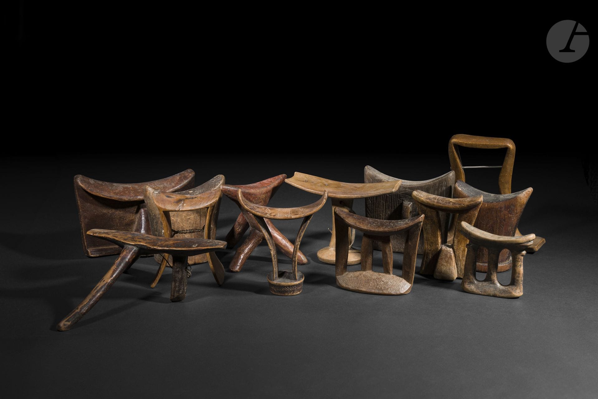 Ensemble de treize appui-nuques, Kenya, Éthiopie et Somalie
Hauteur : de 11 à 23 cm
Bois.
Réunis en un bel ensemble, ces treize appui-nuques illustrent la richesse et la diversité des traditions pastorales de la Corne de l’Afrique. Si tous répondent à une même fonction - soutenir la tête durant le sommeil tout en préservant les coiffures - ils présentent une étonnante variété de silhouettes, de systèmes de piétement et de solutions sculpturales. Cet ensemble témoigne du remarquable savoir-faire des artisans de la région, capables de renouveler une même typologie au travers de formes d’une grande inventivité.

Provenance : 
Galerie parisienne.