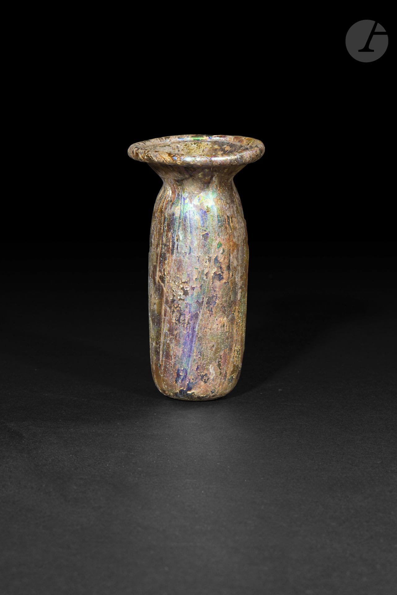 Flacon à panse tubulaire surmontée d’une lèvre évasée
Verre à fortes irisations polychromes.
Art romain, Méditerranée orientale, IIe-IIIe siècle
Hauteur : 8,3 cm