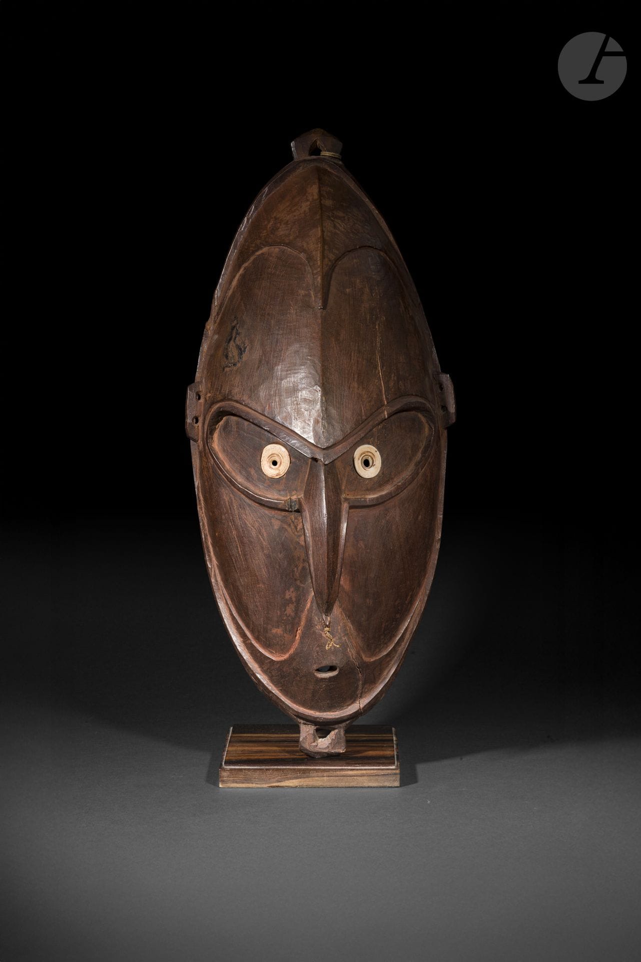 Masque, vallée de la rivière Ramu, Papouasie-Nouvelle-Guinée
Hauteur : 63 cm
Bois et coquillages.
Les masques de la vallée de la rivière Ramu figurent parmi les expressions les plus marquantes de l’art de Papouasie-Nouvelle-Guinée. Destinés aux cérémonies et aux rituels, ils donnaient corps à des êtres ancestraux ou spirituels dont la présence était invoquée lors des grandes célébrations communautaires. Ce bel exemplaire se distingue par la force de sa sculpture (taillée à la pierre) et par ses yeux incrustés de coquillage, dont l’éclat confère au regard une intensité remarquable. L’équilibre de ses volumes, la sobriété de sa composition et la qualité de sa sculpture illustrent le talent des artistes de la région, dont les œuvres sont aujourd’hui reconnues parmi les plus puissantes de l’art océanien.
(Sans socle).

Provenance : 
Galerie Holger Braun, Allemagne.