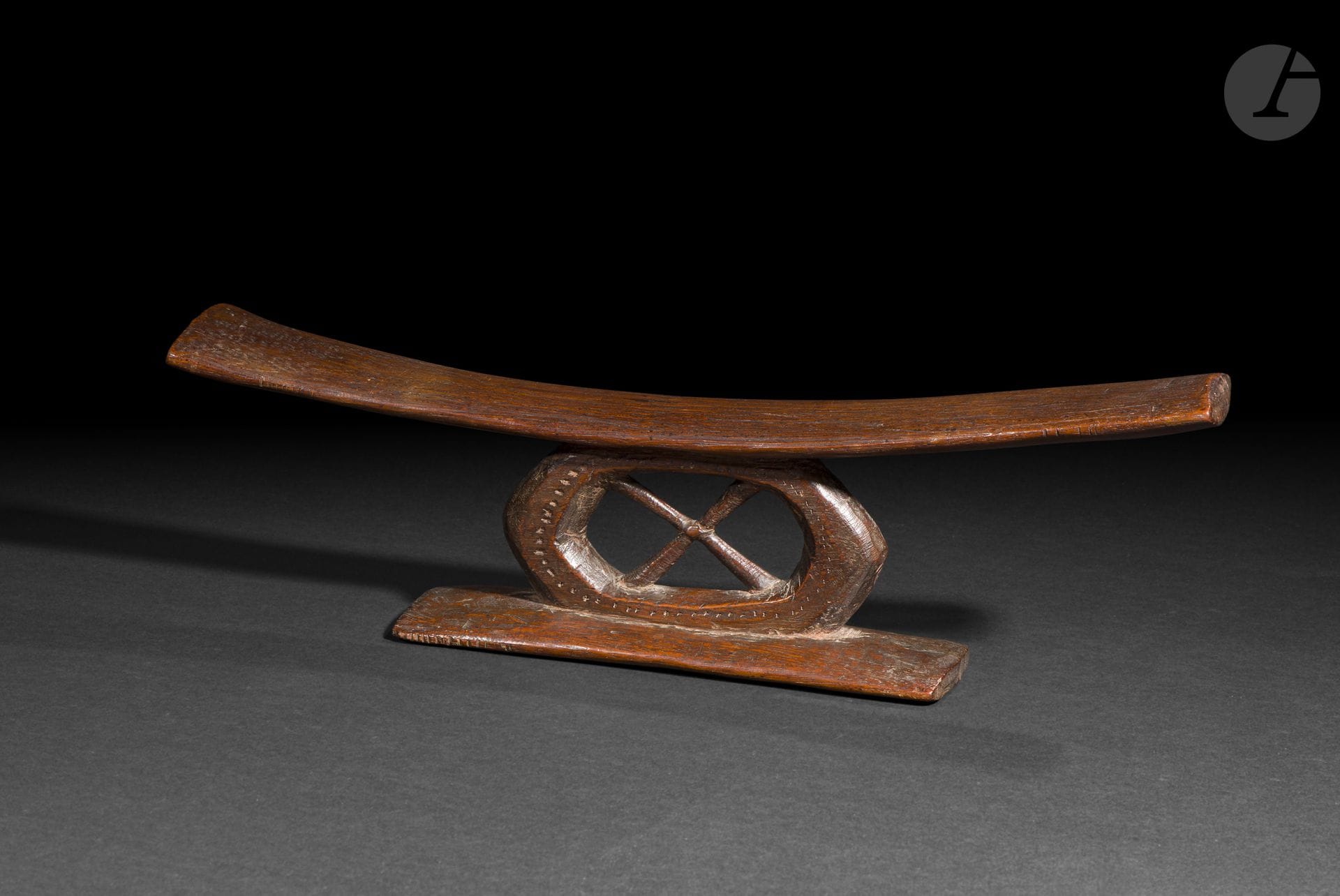 Appui-nuque monoxyle, archipel des îles Fidji
Longueur : 40,5 cm
Bois.
Cet élégant appui-nuque, sculpté dans un seul bloc de bois, se distingue par son montant central ajouré et son décor finement ponctué de petites cupules. Destiné à soutenir la tête durant le sommeil tout en préservant les coiffures, il illustre le raffinement des productions fidjiennes, où la recherche de l’équilibre des formes s’accompagne d’une discrète richesse ornementale.

Provenance : 
Anthony Meyer, Paris.