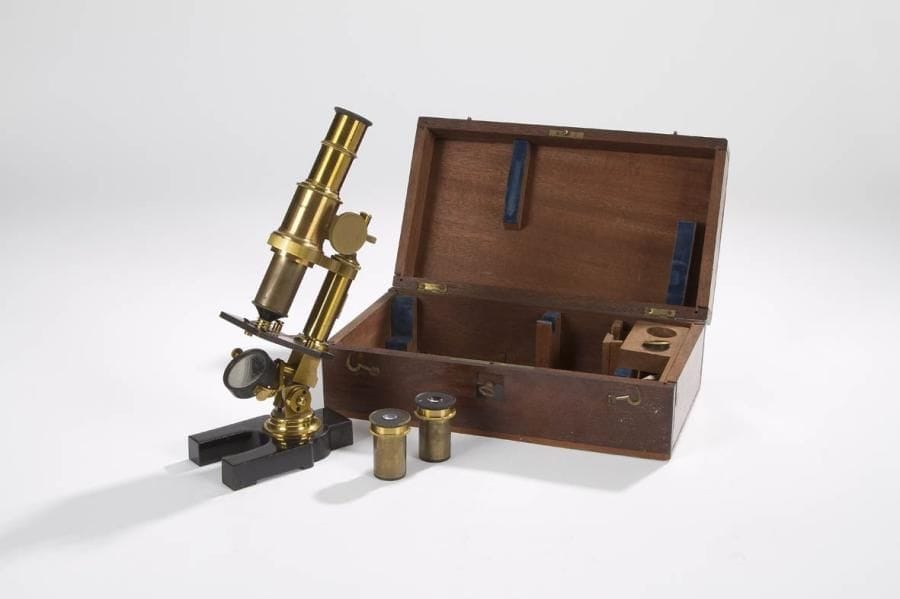 Un microscope, en laiton poli et verni, pied en fonte laquée noire. Signé W. Schwartz. Beau modèle avec son coffret en noyer verni contenant 2 oculaires et un objectif. Hauteur: 26 cm