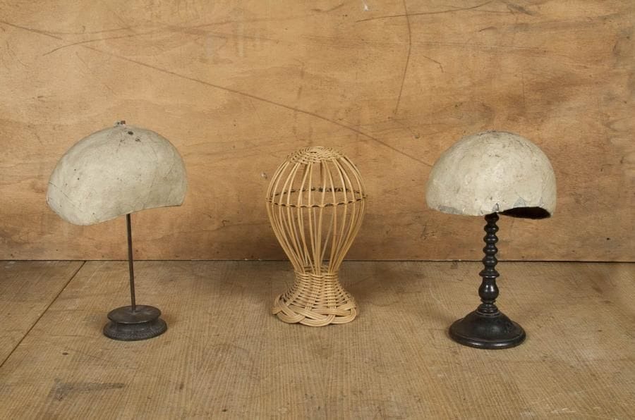 3 Supports pour chapeau de dame, un à pied tourné en bois noirci, un autre en métal et un en osier. Léger accident sur une des formes