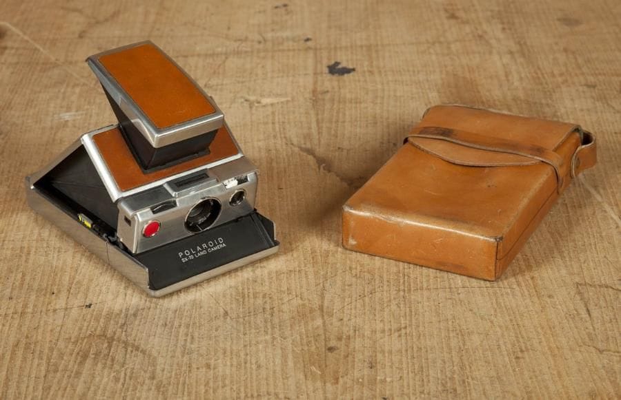 Un appareil polaroid, pliable. SX-70. Corps acier inox et gainé cuir. Avec sa sacoche en cuir souple. Pour format 8,5 x 10 cm. Beau modèle luxe. C. 1970
