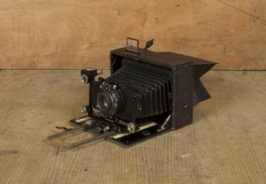 Appareil photographique à soufflet Toska 330. Chambre en bois gainé cuir granité. Objectif avec obturateur DRGM. Pour format 10 x 15 cm. Hauteur: 14 cm