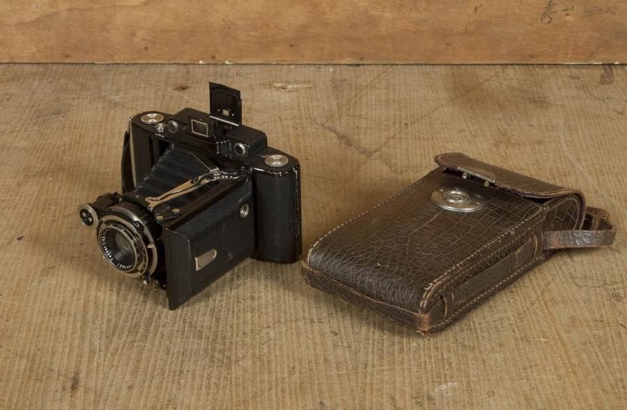 Appareil à soufflet photographique Super Ikonta Zeiss Ikon pour film bobine. Obturateur Compur, Zeiss Ikon, objectif Carl Zeiss Jena, Tessar 1:4.5. Corps gainé de cuir granité. Avec sa sacoche cuir imitation crocodile. C. 1945. Hauteur: 16 cm
