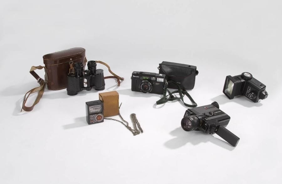 Appareil photo Fujica Auto Focus, matière moulée. C. 1960. On joint: - Posemètre de précision à cellule de marque Réalt, avec son étui de protection en cuir. Lecture sur aiguille, avec cartes d'adaptation et de corrections d'échelles de valeurs. C. 1950. - Paire de jumelles Campalux avec étui cuir, grossissement 8 x 32. Société Générale d'Optique Paris. C. 1950. - Camera super 8m/m Canon 514 XL, matière moulée, C. 1960. - Flash électronique Vivitar, matière moulée. C. 1960
