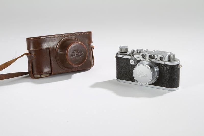 Appareil photographique 24 x 36 mm, Leica.  Corps métal, partie supérieure satinée gris argent, le reste gainé cuir granité, avec son étui cuir. Objectif Summar f5cm 1:2, No227820. Obturateur 20e au 1000e de seconde. Gravé sur le dessus du boitier : "Leica D.R.P.S.T. Ernst Leitz Wetzlar N° 241 456". C. 1950.