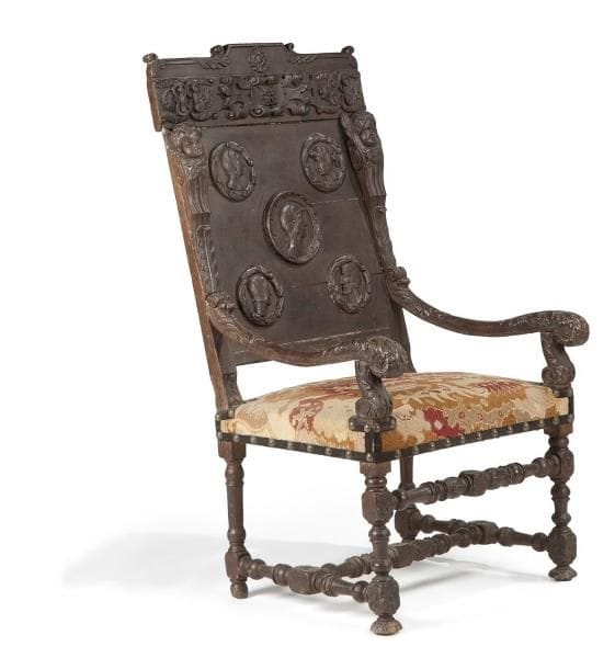Fauteuil en noyer tourné et sculpté, les montants à tête d'angelots prolongés par des accotoirs feuillagés; reposant sur un piètement à entretoise; le fond du dossier et sa partie supérieure à décor de profils, rinceaux stylisés et rosaces (associés). Travail probablement italien de la fin du XVIIe siècle (composite). Hauteur: 123 cm - L.: 66 cm