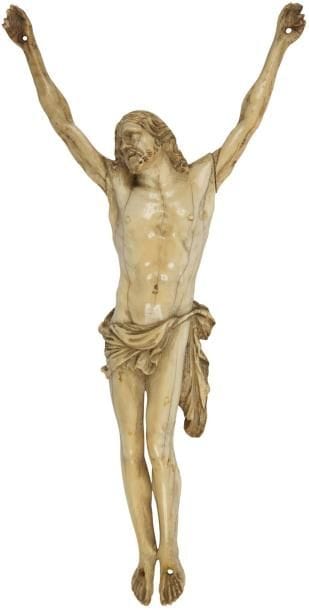 Christ en ivoire sculpté, tête inclinée sur l'épaule droite, périzonium retenu par une cordelette, jambes et pieds parallèles. XVIIIe siècle. Hauteur: 19,5 cm (Accidents aux doigts)