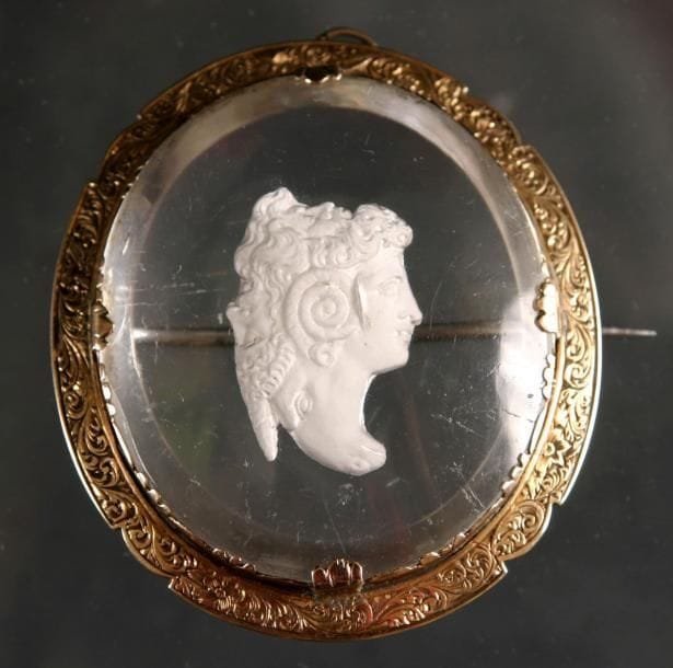Montcenis
Broche en cristal, ornée du profil d'une jeune femme à l'antique (petite fêlure). Monture en or. Haut. 5 cm