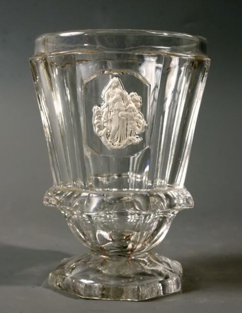 BACCARAT
Gobelet caréné à piédouche en cristal moulé à côtes plates, orné de la Vierge et de l'enfant Jésus portant un globe surmonté d'une croix et posant les pieds sur un serpent. Haut. 11,6 cm