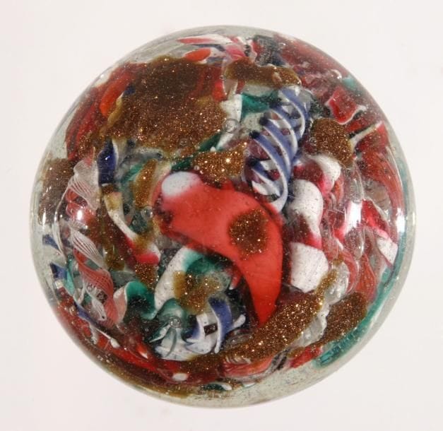 MURANO
Presse-papiers à motif d'aventurine et de torsades blanches et polychromes présentées en pêle-mêle. Diam. 6,2 cm - Haut. 3,6 cm