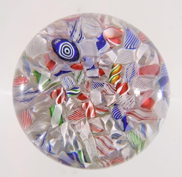 BACCARAT
Presse-papiers à motif de cannes et torsades polychromes et blanches présentées en pêle-mêle. Diam. 5,9 cm - Haut. 4,5 cm