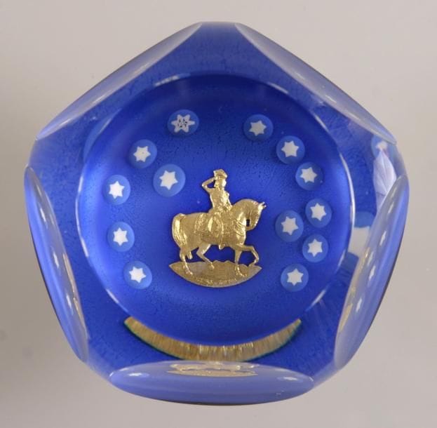 SAINT-LOUIS
Presse-papiers signé et daté SL 1976, à fond bleu orné d'un paillon d'or représentant Georges Washington à cheval encadré de treize étoiles blanches. Produit pour le bicentenaire de l'indépendance des États-Unis d'Amérique. Taille à cinq pontils et fenêtre supérieure. Diam. 8,5 cm - Haut. 5,6 cm