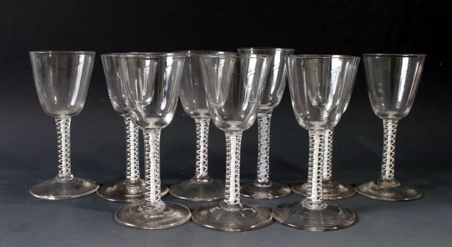 Angleterre
Neuf verres à pied (8+1) en flint glass, les jambes ornées d'une torsade blanche filigranée. Fin du XVIIIe siècle. Haut. entre 15,3 et 15,7 cm