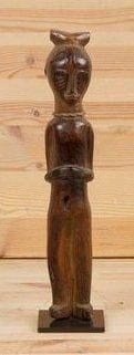MOSSI/NUNA (Burkina Faso) Flûte. Superbe flûte anthropomorphe, le personnage les bras repliés sur le ventre; très belle patine brune de grande utilisation, corde de suspension autour du cou. Ce type de flûte est rare, le personnage représentant un esprit protecteur ou un ancêtre clanique. Hauteur: 30 cm
