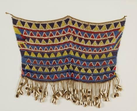 KIRDI (Cameroun) Pagne cache-sexe. Cet ornement pubique est constitué d'un perlage géométrique multicolore avec une frange de cauris. Appelé "Pikuran", il constituait le vêtement traditionnel féminin, jouant une fonction d'identification sociale. Hauteur: 41 cm - Largeur: 50 cm
