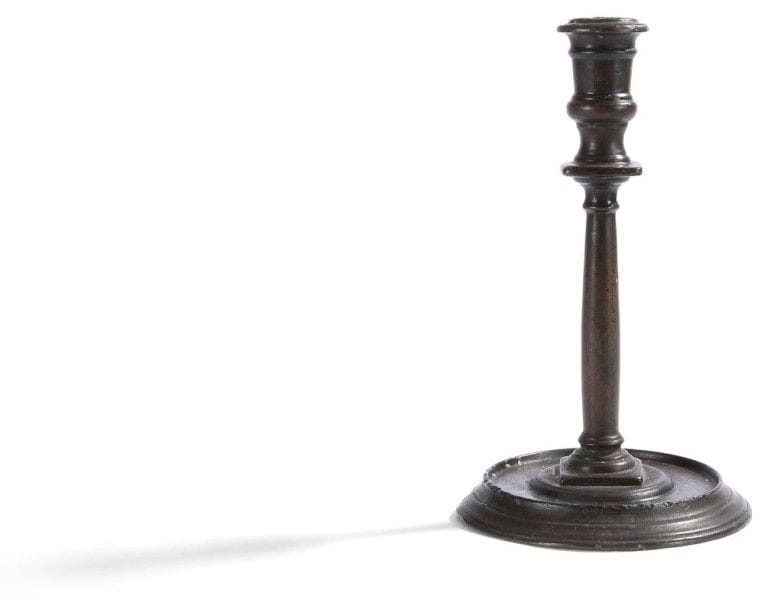 Flambeau en bronze patiné, le fût en colonne baguée reposant sur une base circulaire à mouluration.
Fin du XVIIe siècle.
H. : 24 cm