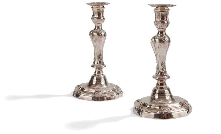 Paire de flambeaux de forme balustre en bronze réargenté, la base mouvementée, moulurée et feuillagée ; gravés d’armoiries. 
XVIIIe siècle.
H. : 25,5 cm