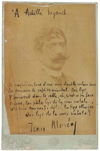 Jean MORÉAS (1856-1910) poète. Photographie avec dédicace autographe signée; 16,5x10,5 cm sur carton au nom du photographe Otto (mouillures et fentes).{CR}Dédicace «À Achille Segard», avec poème (6 vers): «Je naquis au bord d’une mer dont la couleur passe/ En douceur le saphir oriental»…
