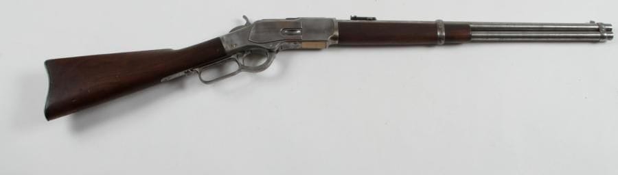 Carabine Winchester modèle 1873, calibre 44-40. Canon rond avec hausse et reste de marquage. Queue de culasse «Model 1873». Anneau de selle. Crosse et fût en noyer ciré. Plaque de couche frappée «3.8.C.F.».
Catégorie C.
B.E. Finition poli blanc. Fabriquée en 1891