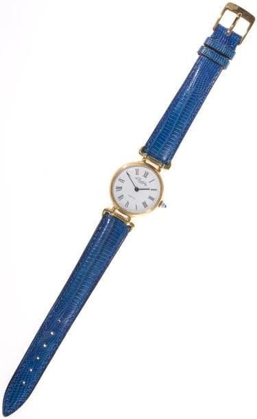 ALEXIS BARTHELAY
Montre de dame en or jaune, cadran rond, fond blanc, index chiffres romains, remontoir agrémenté d'une pierre bleue, bracelet cuir boucle métal, mouvement quartz. Signée.Poids brut: 24,77 g