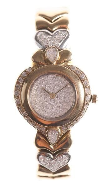 Montre de dame en or jaune, le fond et la lunette pavés et sertis de diamants, les attaches en forme de coeur pavées de diamants, mouvement quartz. Poids brut: 66,90 g