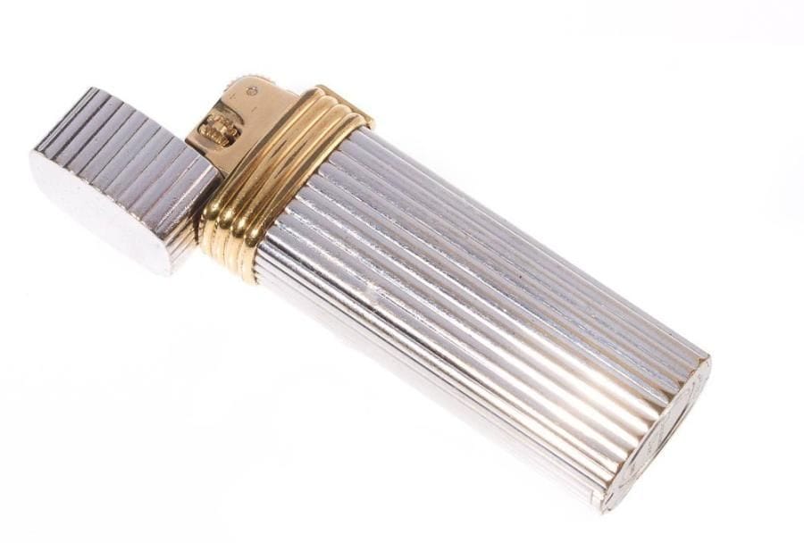 CHRISTIAN DIOR
Briquet en métal argenté et doré godronné.