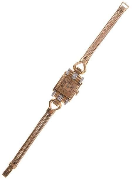 Montre de dame en or jaune, cadran carré, fond satiné, index batons et chiffres arabes, les anses en rouleaux agrémentés de diamants, bracelet double "queue de rat" en or jaune, mouvement mécanique. Poids brut: 42,5 g (mouvement à réviser)