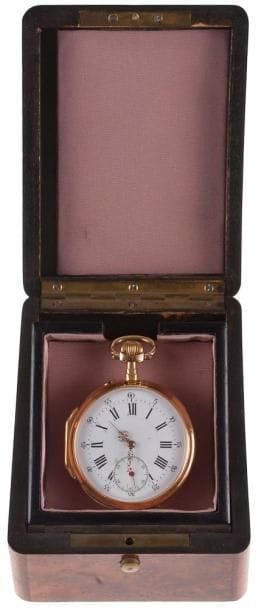 Montre gousset en or, trotteuse à 6h. Aiguilles style Louis XV, cadran émaillé.Fond de boîte avec initiales entrelacées usagées, double boîte or avec gravure H Pédraglio Nanterre, mécanisme bon état, échappement ancre, balancier compensé coupé, spiral Breguet, chatons empierrés, remontage à dents de loup. Avec un coffret présentoir en bois de loupe.Poids brut: 85 g