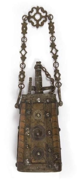 Cinq poires à poudre en bois et laiton, Maroc, fin XIXe-déb. XXe siècle L'une en forme de corne, embout et couvercle ciselé, avec chaîne. Une seconde en forme de fuseau, à cerclage de laiton. Une troisième, trapézoïdale, à motifs gravés géométriques. Une quatrième trapézoïdale à cabochons. Une cinquième, ronde, à réseaux d'arabesques sur une face et d'une rosette centrale sur l'autre. Dim.: longueur: 1re: 36 cm; 2e: 23,5 cm; 3e: 21,5 cm; 4e: 34 cm avec chaîne et 24 cm sans; 5e: 27,5 cm avec chaîne et 17,5 cm sans. Five brass and wooden powder flasks, Morocco, late 19th century - early 20th century