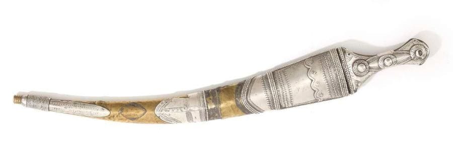 Poignard Jambiya wahabite, Arabie Saoudite, XXe siècle Lame courbe à fourreau et monture en laiton et partiellement en argent à décor incisé de motifs géométriques et rosettes. Dim.: 52,5 cm An arabian dagger, Jambiyya, 20th century