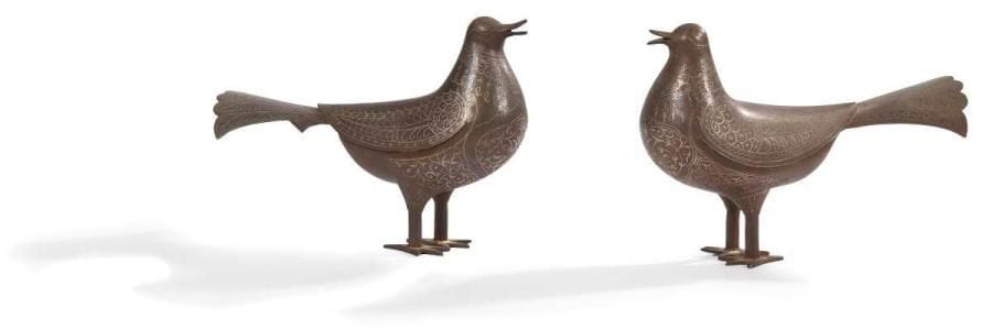Paire de pigeons en acier, Iran qâjâr, XIXe siècle Ronde-bosse en acier à décor peint de filets d'argent soulignant le plumage de l'oiseau sur les ailes, la queue et le torse. H.: 17,5 cm; long.: 25 cm A pair of steel pigeon, Qajar Iran, 19th century