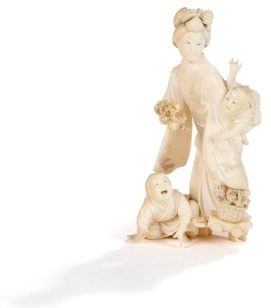 JAPON - Epoque MEIJI (1868 - 1912)
Okimono en ivoire à patine jaune représentant une jeune femme debout portant un enfant, un autre à ses pieds. (Petites restaurations). Haut.: 12,5 cm