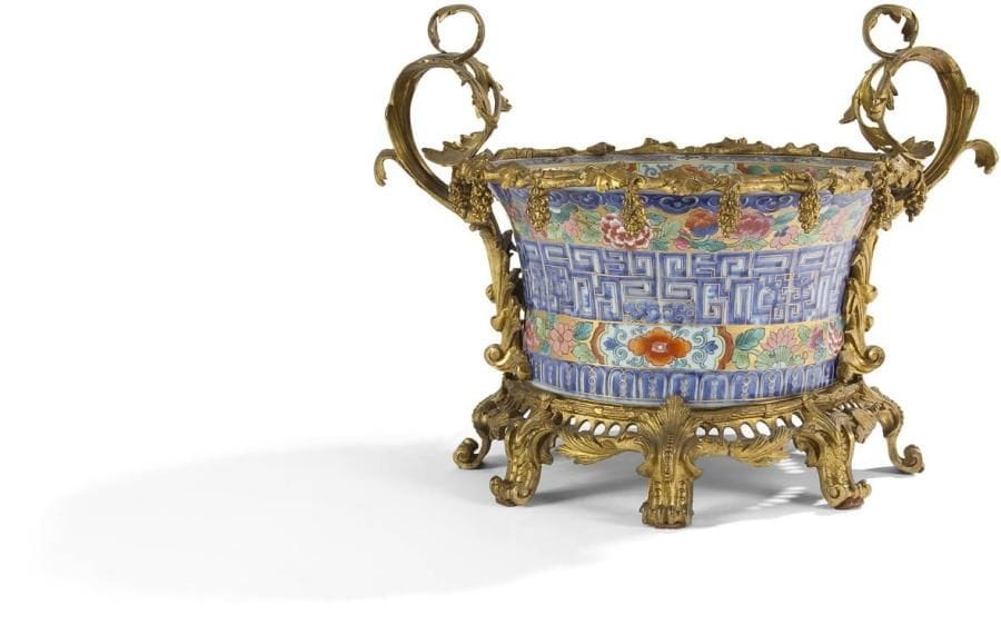 Grand vase en porcelaine dans le goût de la porcelaine de Chine de la Famille Verte; richement orné d'une monture en bronze doré à larges anses feuillagées; la base ajourée à pieds en volute.
Style Louis XV.
H.: 40 cm - L. : 67 cm - P.: 43 cm
