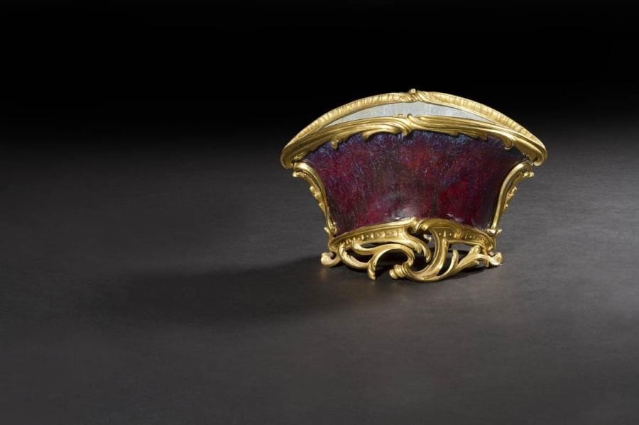 Petit vase en porcelaine de Chine aubergine (remploi d'éléments) à monture de bronze doré à décor de feuillages, rocailles et enroulements.
Style Louis XV, XIXe siècle.
H.: 12 cm - L.: 19 cm
