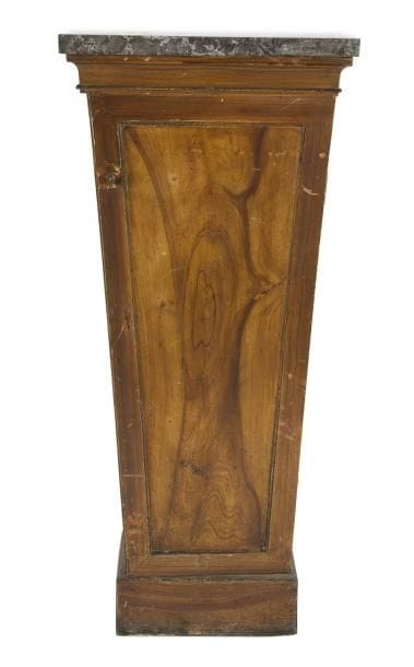 Gaine en bois peint en faux bois ouvrant à une porte en façade; dessus de marbre gris Sainte-Anne.
XIXe siècle (accidents).
H.: 105 cm - L.: 46,5 cm - P.: 29 cm
