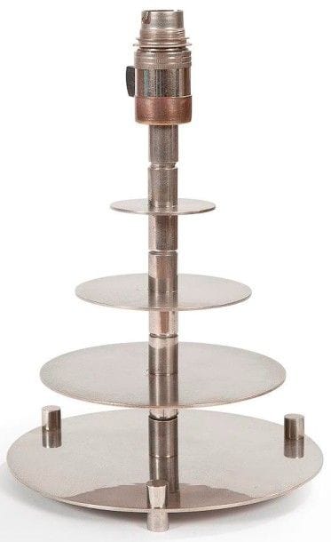 TRAVAIL MODERNISTE
Pied de lampe en métal nickelé. Le fût central cylindrique reçoit quatre disques disposés en gradin. Pieds en cylindre traversant. Hauteur (douille comprise): 27 cm